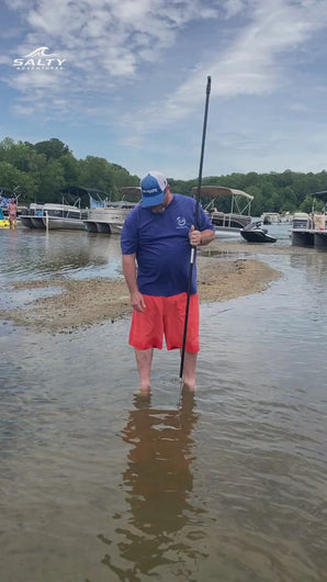 Boater using the Sand Saber XL 8FT shallow water anchor pole to secure a boat in shallow water at a sandbar
